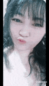 a woman with long black hair is making a funny face with her mouth open .