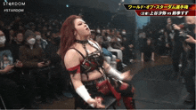 a female wrestler stands in front of a crowd with the word stardom on the bottom left