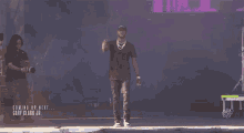 gary clark jr. is standing on a stage giving a thumbs up