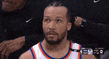 a basketball player is sitting in the stands watching the game