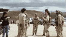 a group of soldiers are standing in a desert area