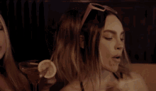 a woman wearing a pink headband and sunglasses is blowing a kiss