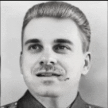 a man with a mustache is wearing a uniform