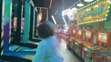 a woman playing a game in an amusement park with a sign that says " smash "