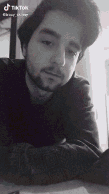 a black and white photo of a man with a beard and a tiktok logo