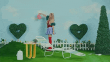 a woman is watering a plant with a watering can in a garden .