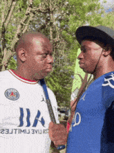 two men standing next to each other one wearing a white shirt that says iia