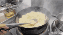 a pan of food is being cooked on a stove with the words made in animotica visible
