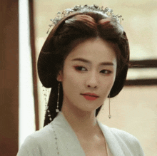 a woman wearing a white dress and a tiara on her head