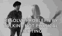 a man and a woman are standing next to each other and talking to each other .