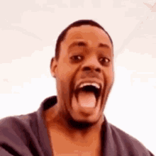a man is making a funny face with his mouth open and his tongue out .