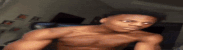 a shirtless young man is taking a selfie in a living room .