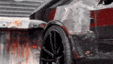 a black car is parked in front of a rusty building .