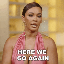 a woman in a pink dress with hoop earrings says here we go again