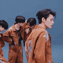 a group of young men are dancing together and one of them is wearing a brown jacket with silver stars on it