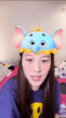 a woman wearing a blue elephant hat with a yellow crown