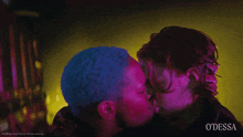 a man and a woman kissing in front of a sign that says odessa