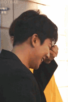 a close up of a person covering their face with their hand and the word dotbae in the corner