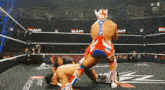 two men are wrestling in a ring with the word raw on the wall