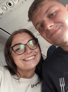 a man and a woman are posing for a picture and the woman is wearing a dirty mind sweatshirt
