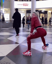 a woman is squatting in front of a levis sign
