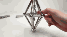 a person is playing with a magnetic toy that looks like a diamond