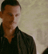 a man with his eyes closed is wearing a black shirt and black jacket