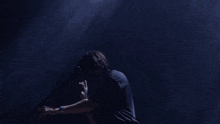 a man in a dark room with his hands folded