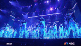 a group of people on a stage with a nbc logo