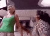 a woman in a green tank top stands next to another woman in a leopard print shirt