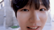 a close up of a young man 's face with a blurred background .