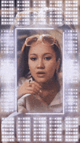 a woman wearing sunglasses and a ring looks at herself in the mirror
