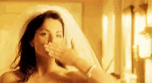 a naked woman in a wedding dress is blowing a kiss to the camera .