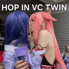 two women in cosplay are kissing each other with the words `` hop in vc twin '' above them .