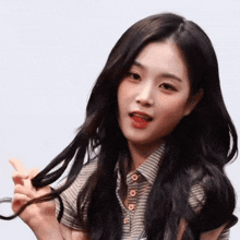 a woman with long black hair is holding her hair in her hands