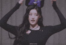 a woman wearing a headband with a purple bow and the name oldman sunny below her