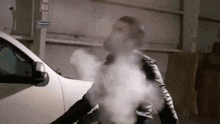 a man is smoking a cigarette in front of a white car .