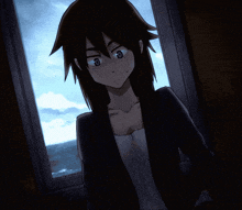 a girl in a black jacket looks out a window