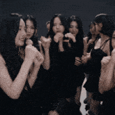 a group of women in black dresses are standing in a circle