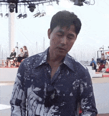 a man wearing sunglasses and a shirt with a floral pattern