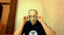 a man wearing glasses and a crown on his shirt
