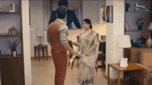 a man and a woman are standing in a living room