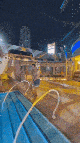 a man is getting out of a swimming pool with a hose attached