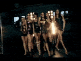 a group of women are dancing on a stage in a club .