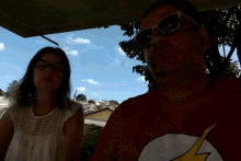 a man and a woman wearing sunglasses and a flash shirt