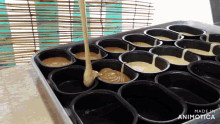 a tray of black cups filled with liquid with the words made in animotica on the bottom