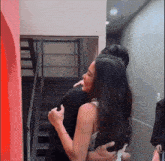 a woman hugging a man in front of a staircase