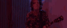 a man is playing an electric guitar in a dark room with red lights .