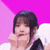 a close up of a girl making a heart shape with her hands .