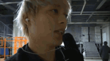 a man wearing ear buds and a glove looks at the camera